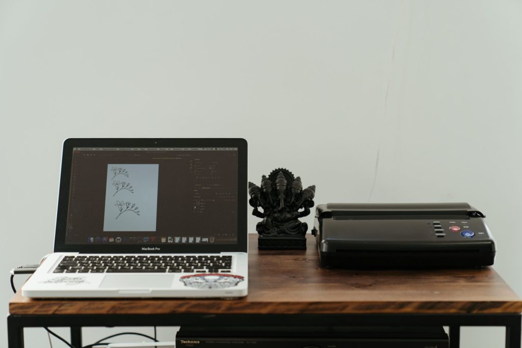macbook pro with printer beside it
