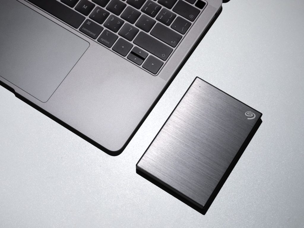 close up shot of macbook and hard drive